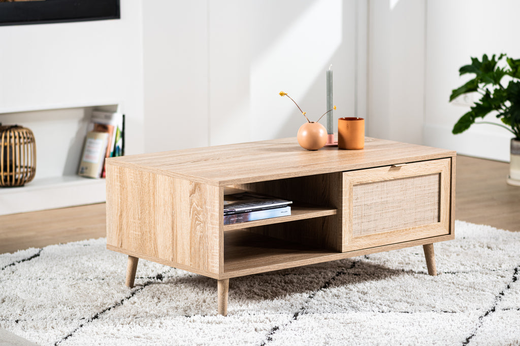 Lichtbruine houten salontafel met opbergvakken, geplaatst op een wit vloerkleed in een moderne woonkamer.