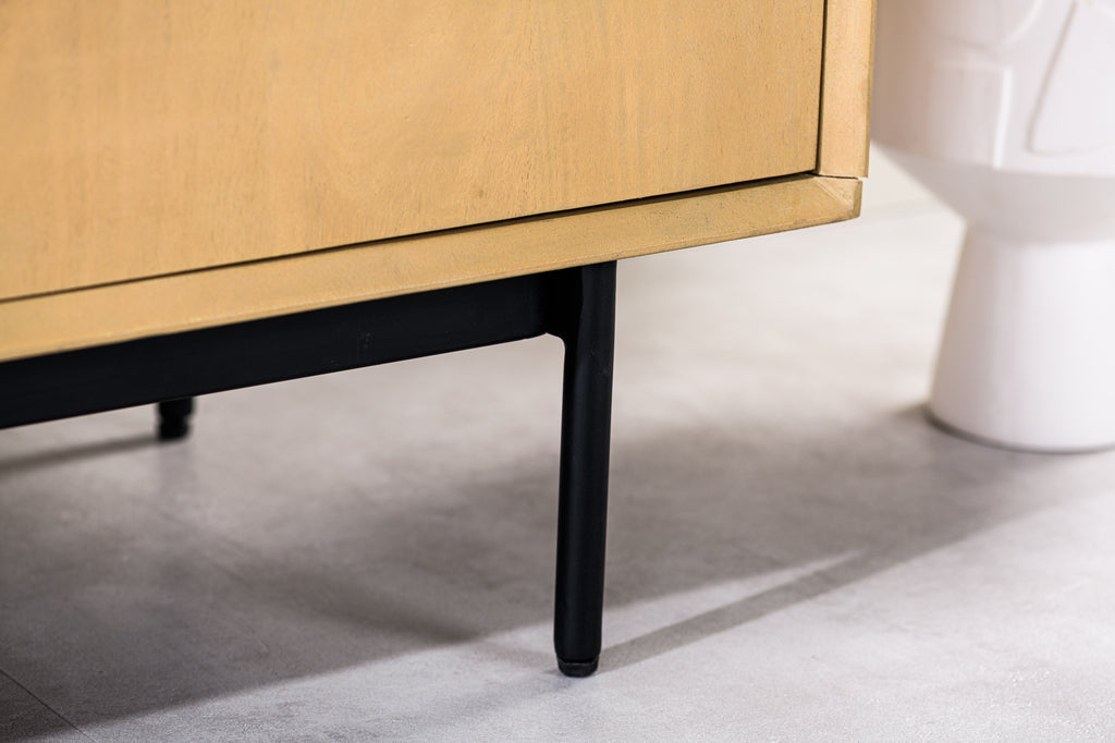 Gedeelte van een houten kast met zwarte poten, naast een witte sculptuur, op een lichtgrijze vloer.