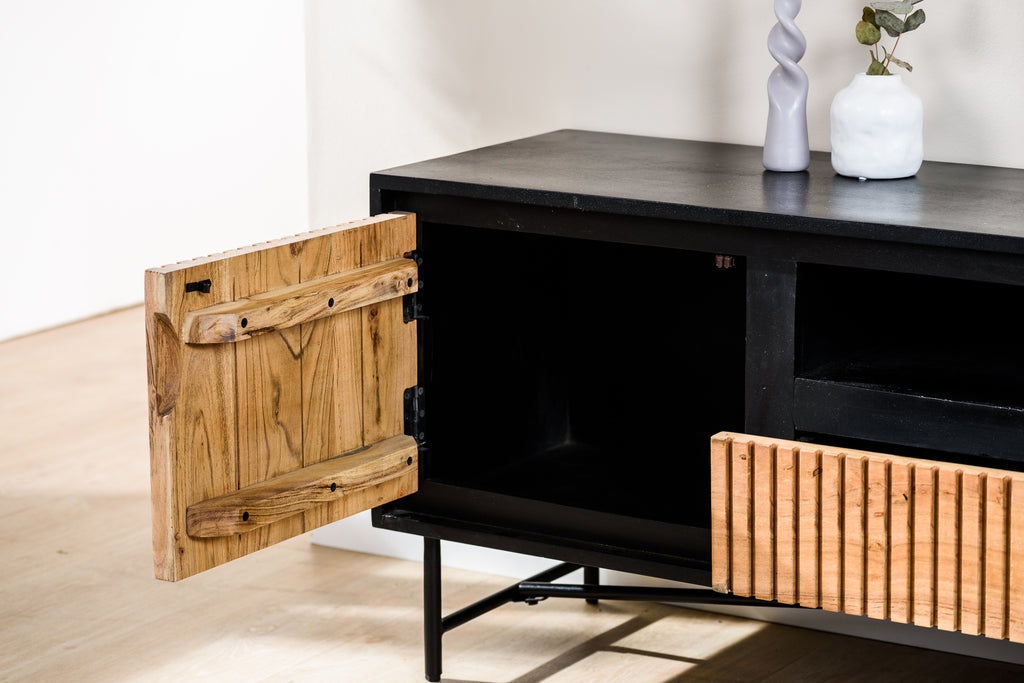 Zwart houten dressoir met open kastdeur, vaasjes bovenop, één met plant. Strakke en moderne uitstraling.