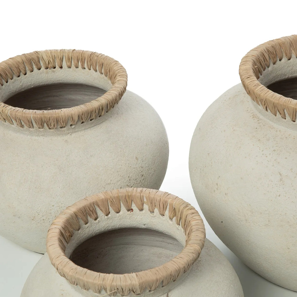Drie beige aardewerken potten met gevlochten randen in natuurlijke kleuren op witte achtergrond.