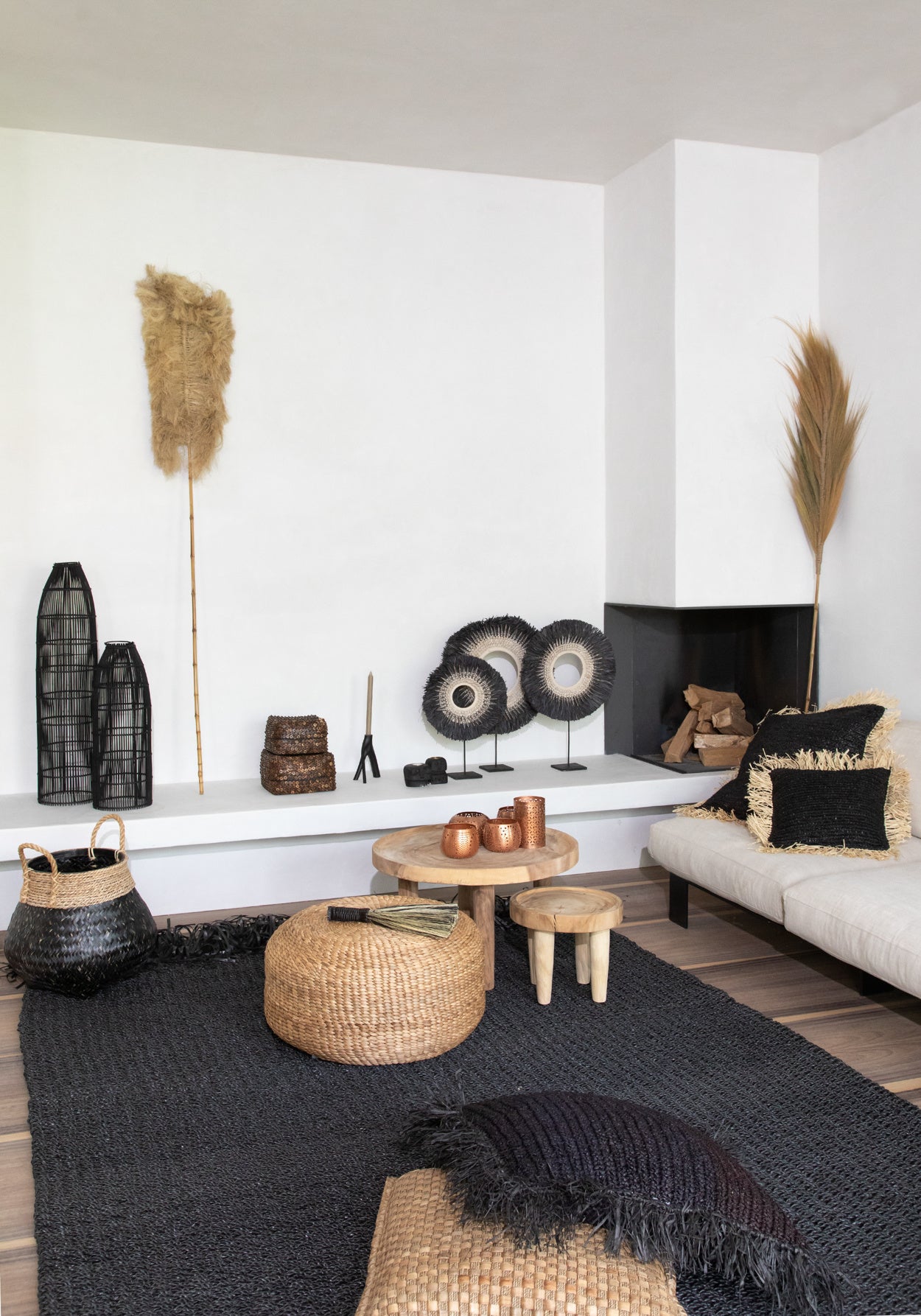 Moderne woonkamer met natuurlijke decoraties, zwart-witte tinten, rotan manden en houten bijzettafels.