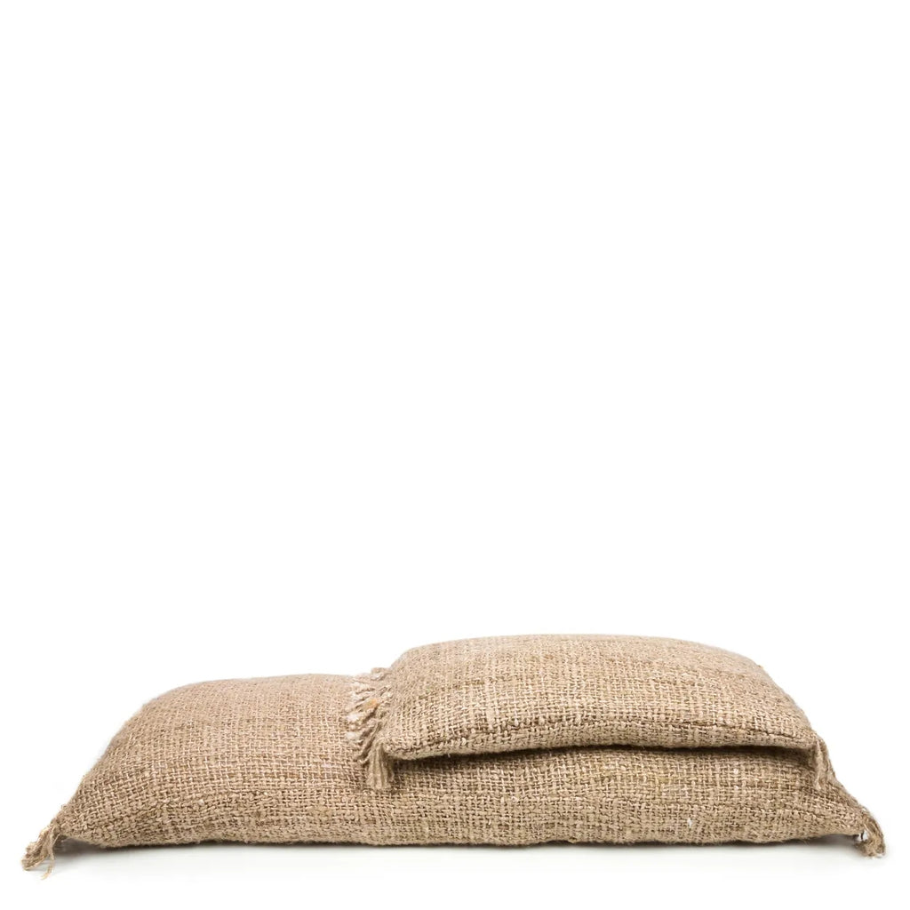 Zacht uitziende beige jute vloerkussen set met ruwe textuur op effen witte achtergrond.