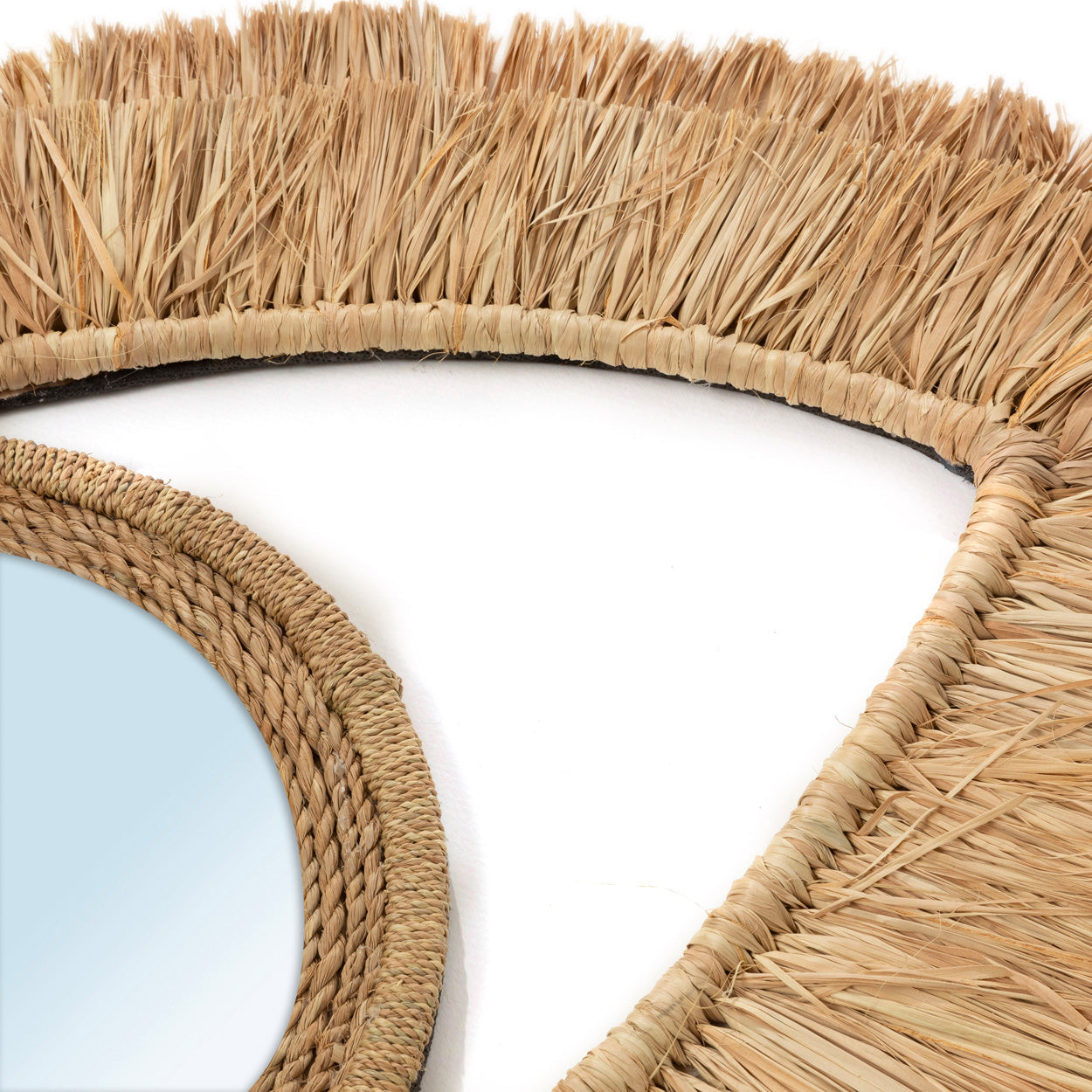 Ronde spiegel met natuurlijke raffia en rotan rand, decoratief vlechtwerk op witte achtergrond.