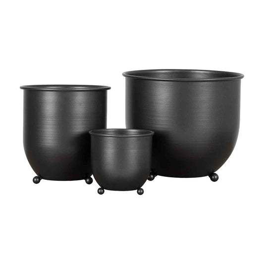 Drie matzwarte metalen bloempotten van verschillende grootte, minimalistisch ontwerp met bolvormige poten.