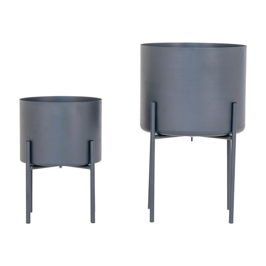 Twee verschillende grijze bloempotten op metalen standaards, één groter en één kleiner, minimalistisch design.
