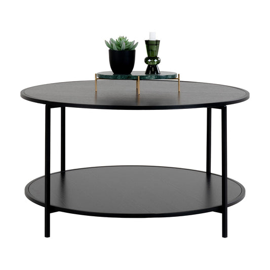 Ronde salontafel met zwarte metalen poten, een vetplant en een groene kandelaar op een marmeren schaal.