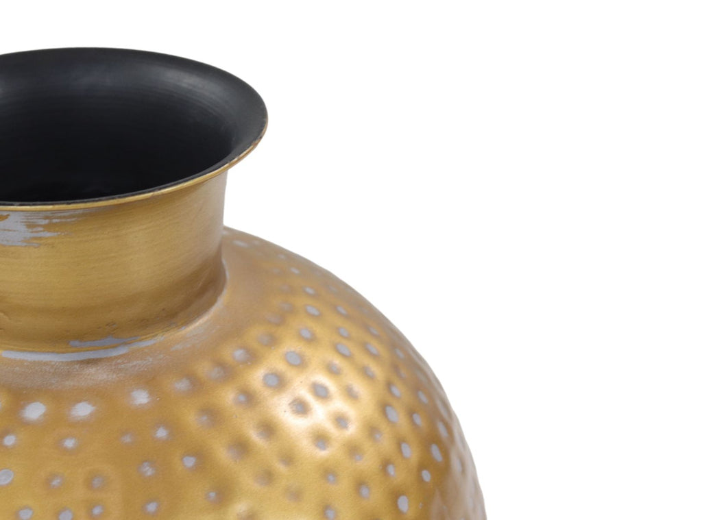 Goudkleurige metalen vaas met hamerslagpatroon, glanzend oppervlak, zwart interieur, detailopname.