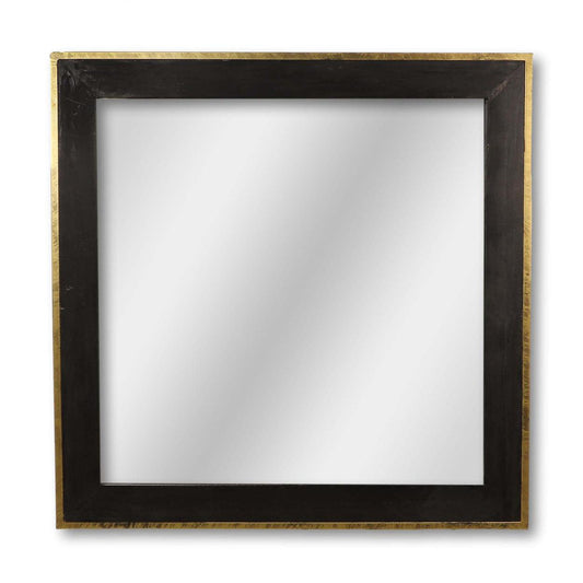 Vierkante spiegel met een brede zwarte houten lijst en subtiele gouden rand, tegen een witte achtergrond.