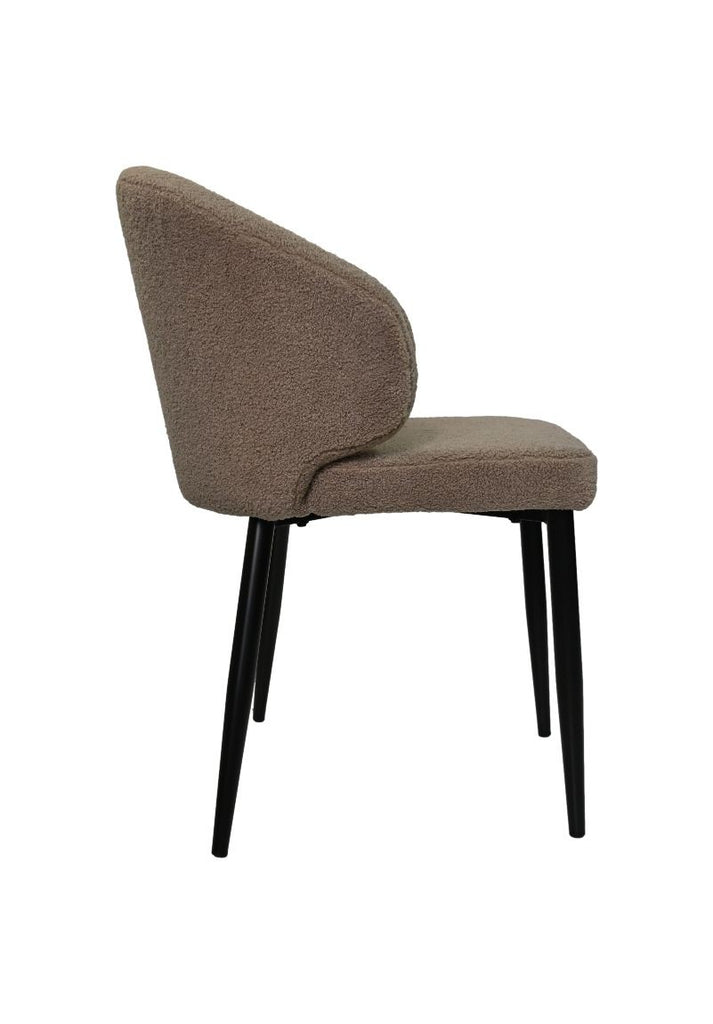 Moderne stoel met beige bouclé stof en zwarte metalen poten, zijaanzicht, minimalistisch ontwerp.