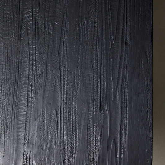 Donkergrijze houten tafel met zichtbare nerfstructuur en lichte glans, rechts afgezet tegen beige achtergrond.