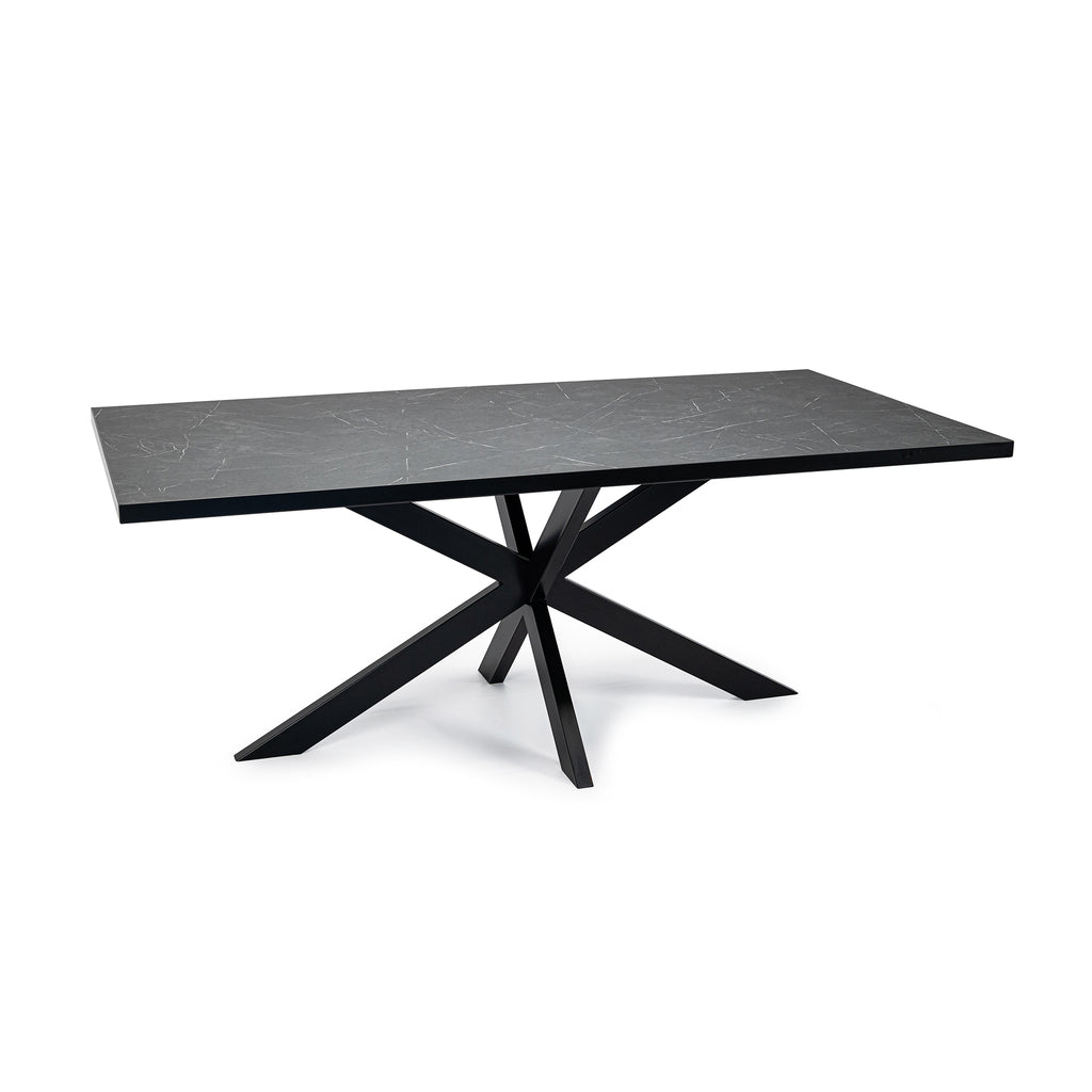Zwarte rechthoekige tafel met marmeren blad en geometrisch metalen onderstel tegen een witte achtergrond.