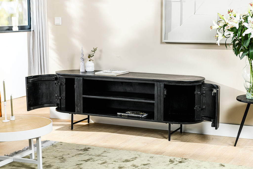 Zwart houten dressoir met geopende deuren, bloemen in een vaas en een licht interieur met groen tapijt.