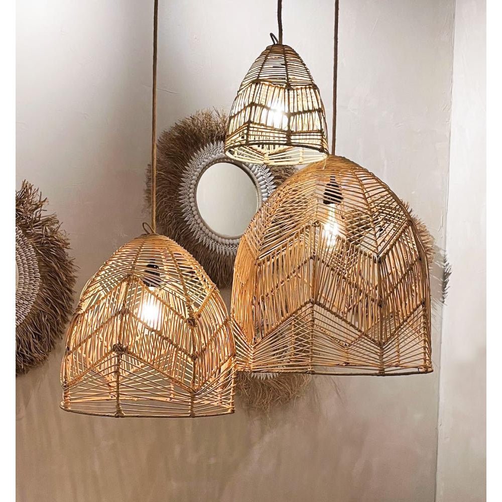 Rotan hanglampen met warme gloed, naast ronde spiegels met natuurlijke frames aan een beige muur.