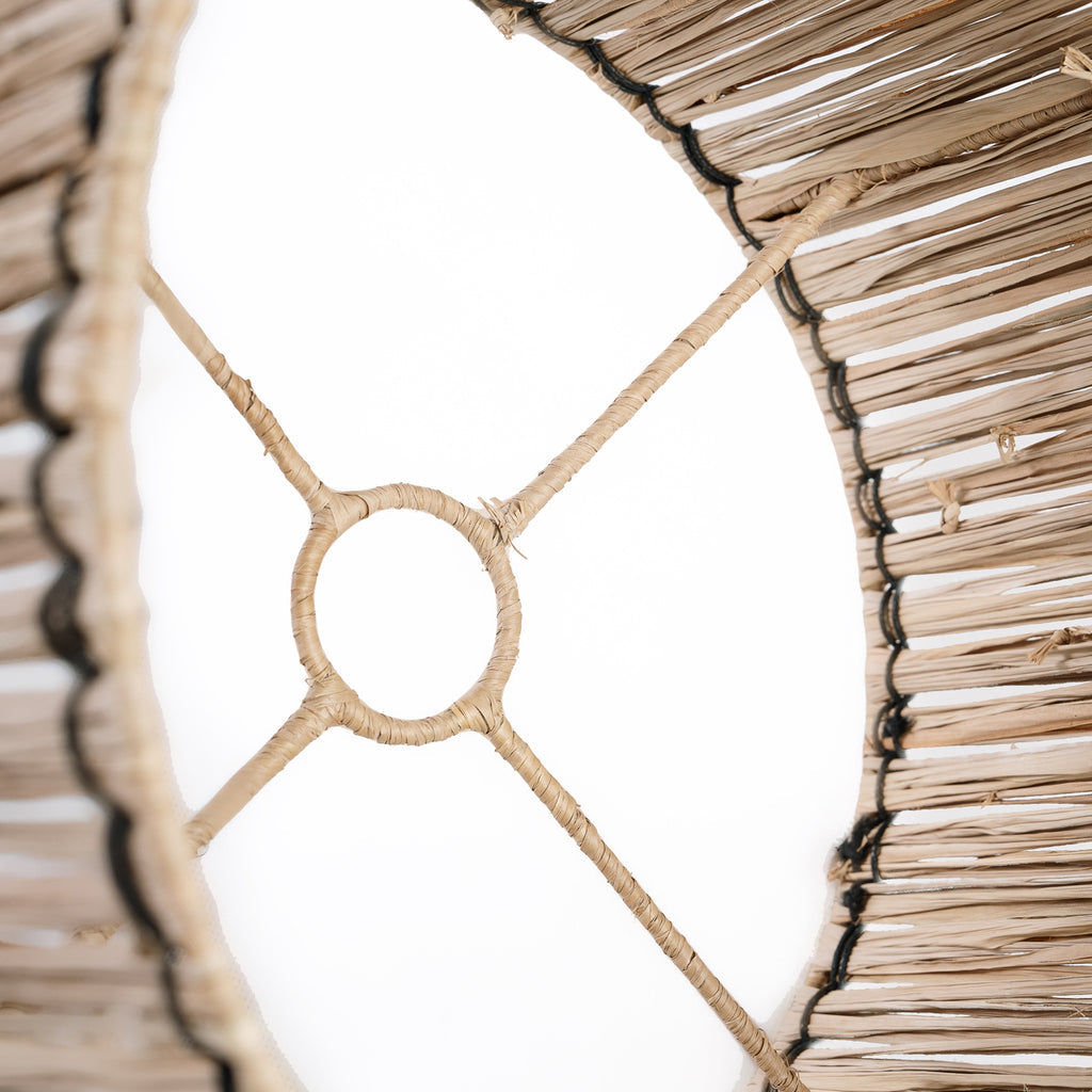 Detail van natuurlijke rotan mand met gevlochten patroon tegen een witte achtergrond.