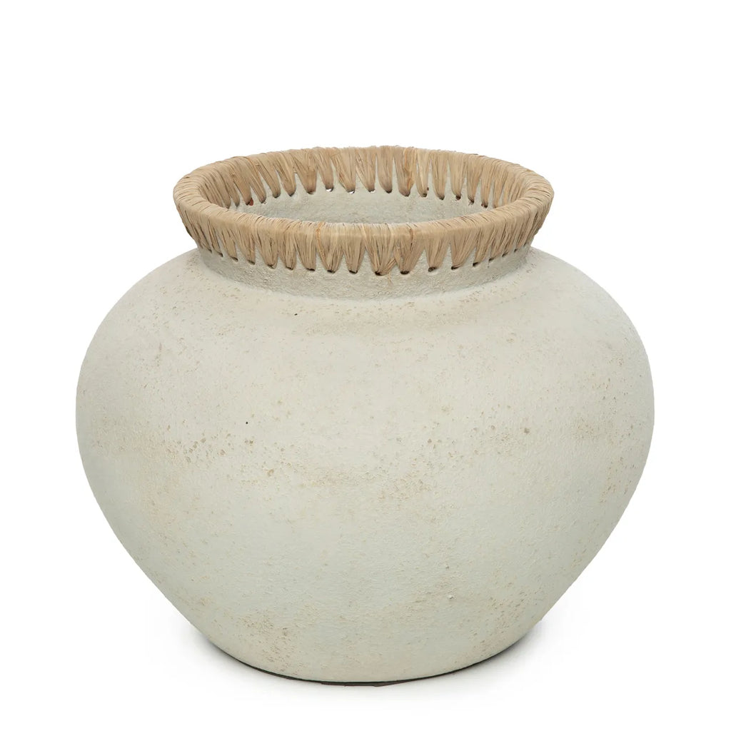 Crème-kleurige pot met ruwe textuur en decoratieve rand van beige geweven vezels aan de bovenkant.