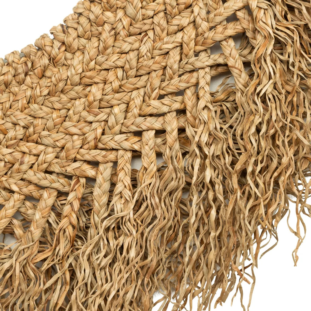Geweven rieten mat met gedetailleerde patronen en rafelige randen in natuurlijke beige tinten.