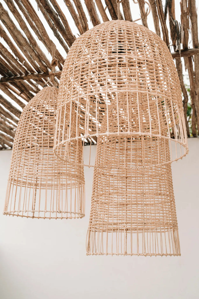 Grote rieten lampen hangen aan een houten plafond, met een rustieke en natuurlijke uitstraling.