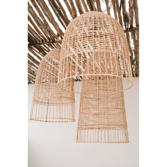 Grote rotan hanglampen in natuurlijke tinten, onder een rustiek houten plafond tegen een witte muur.