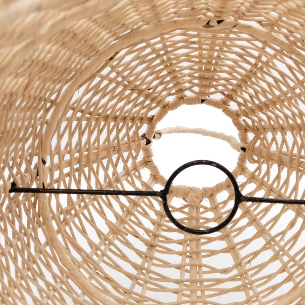 Binnenzijde van een ronde, gevlochten rotan mand met een zwart metalen ring aan de onderkant, witte achtergrond.