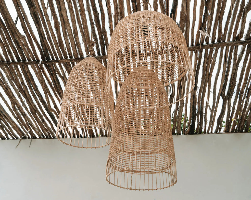 Drie geweven rieten hanglampen aan houten plafond, met natuurlijke, rustieke uitstraling.