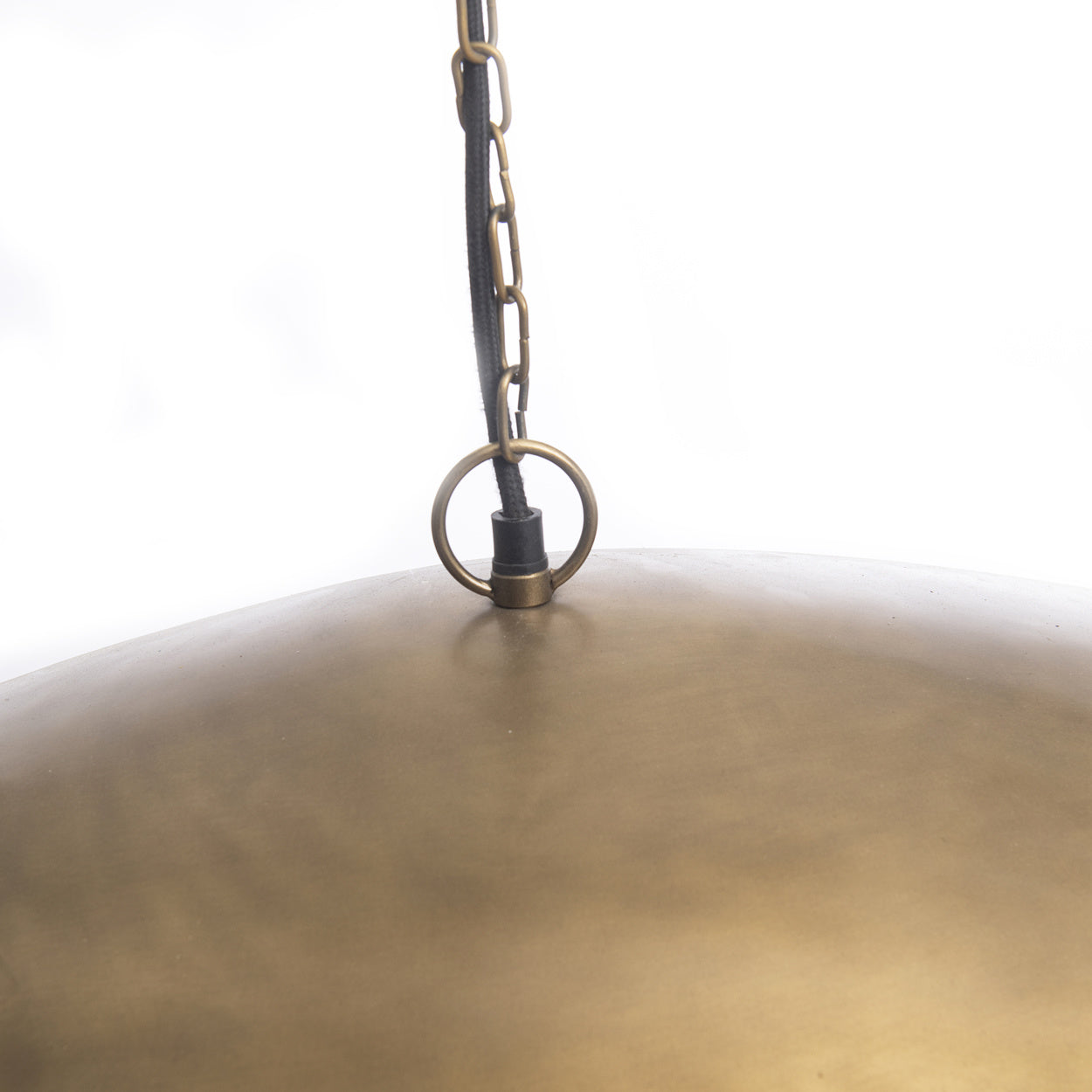 Matgouden metalen gong met ophangring en ketting tegen een witte achtergrond, elegant en rustig moment.