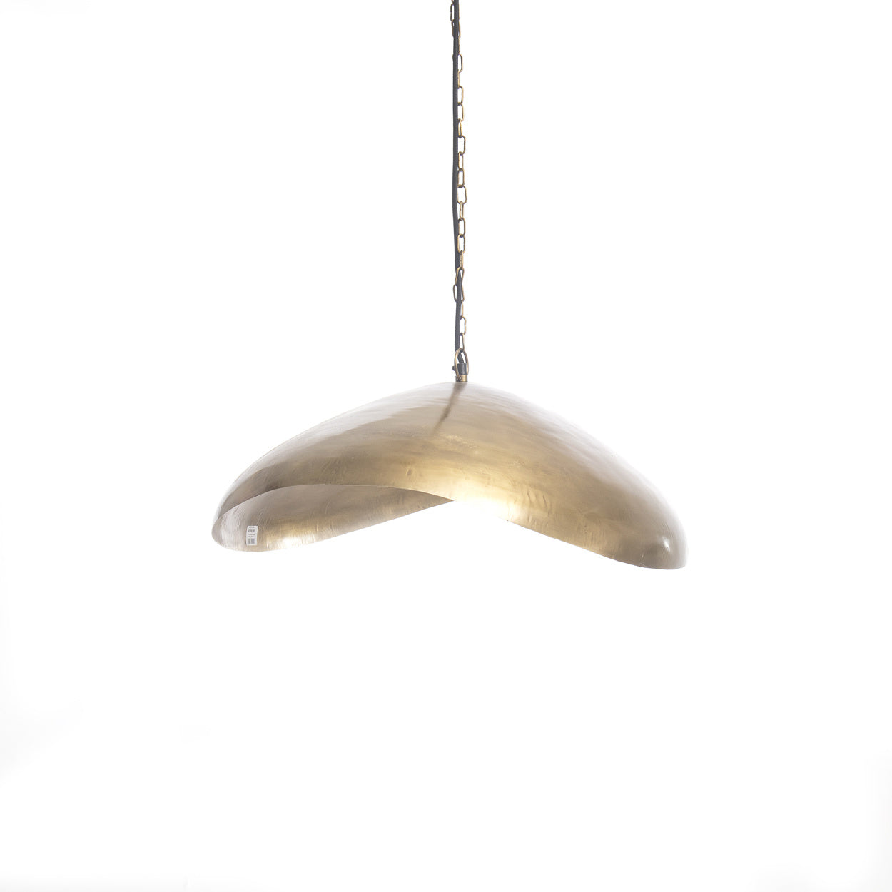 Messingkleurige hanglamp met vloeiende, gebogen vorm, hangend aan een metalen ketting tegen witte achtergrond.