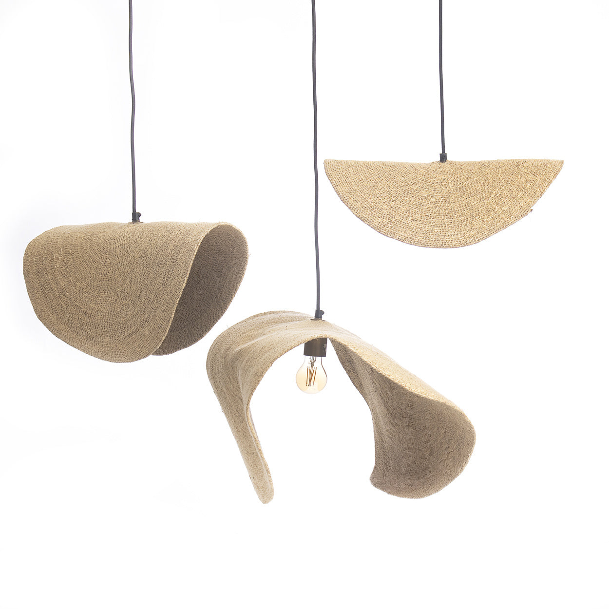 Drie artistieke hanglampen met golvende jute kap, warme gloeilamp en minimalistisch design tegen witte achtergrond.