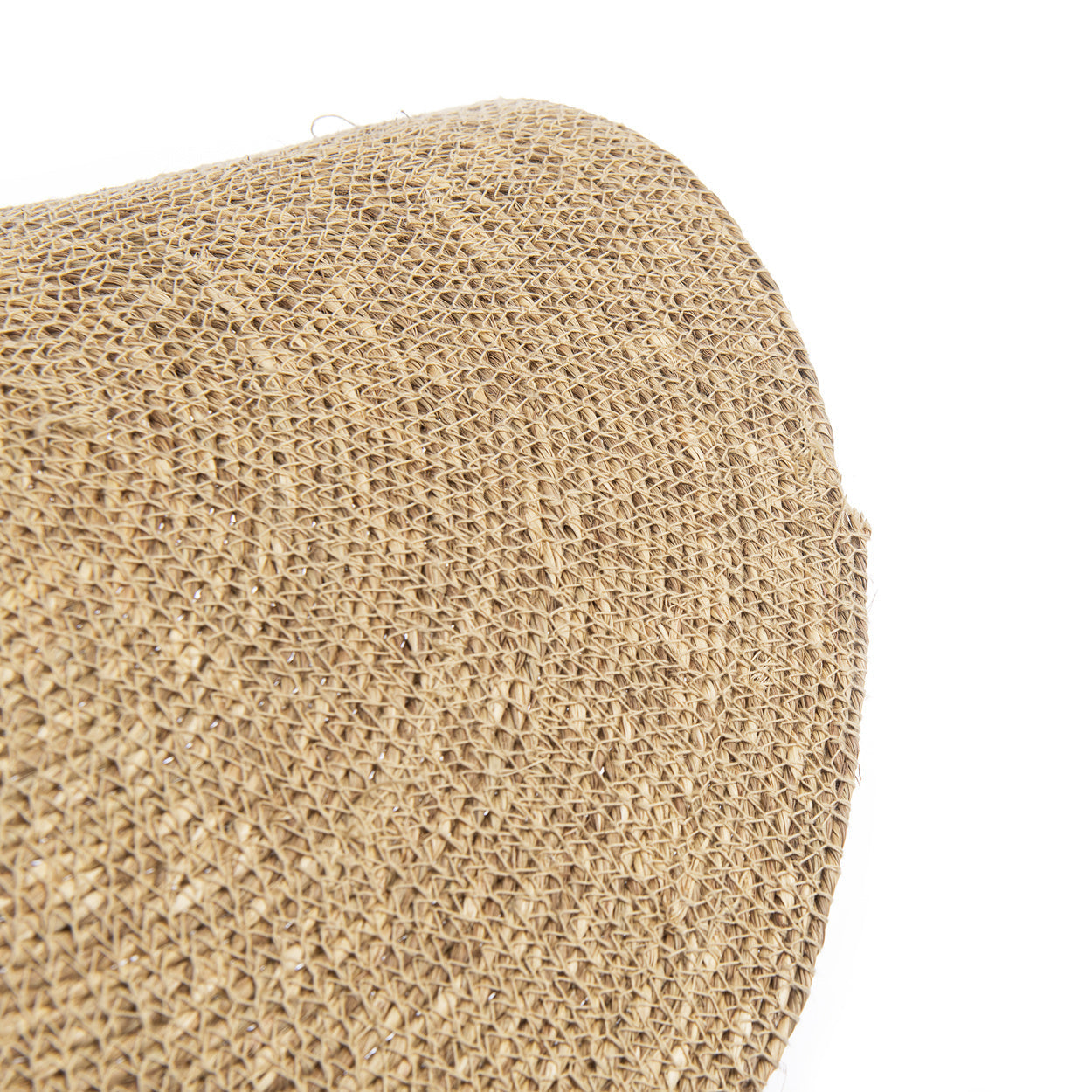 Rond geweven jute placemat met natuurlijke bruine kleur en zichtbare vezelstructuur, vanuit hoek getoond.