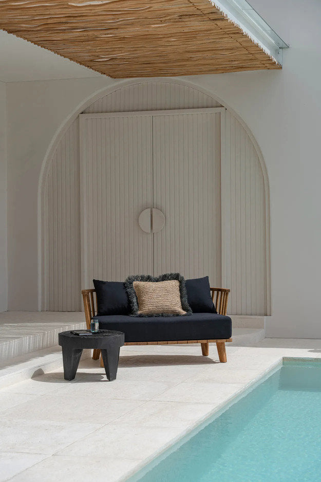 Donkere Madero salontafel van Bazar Bizar naast bank in overdekte patio, met matte zwarte suarhout look