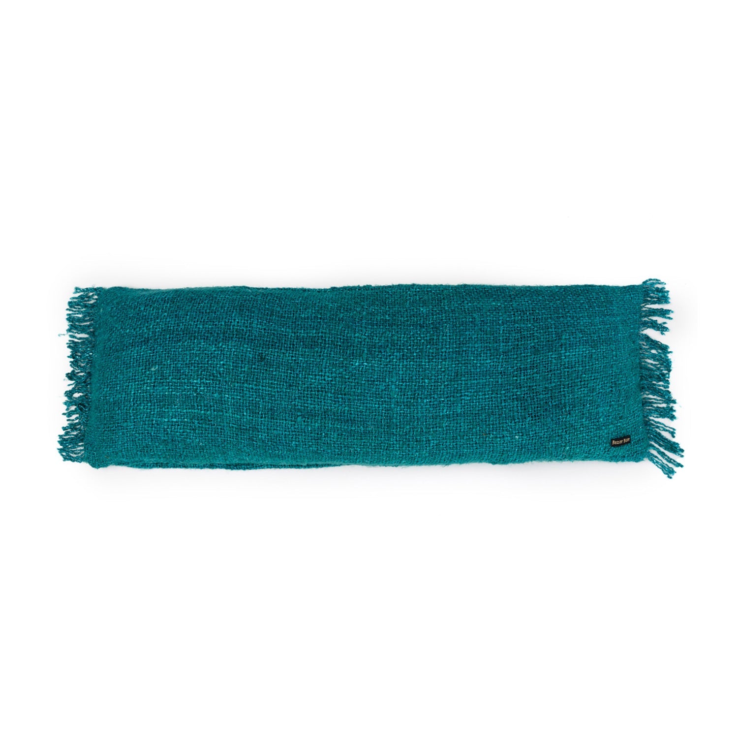 Turquoise kussen met grove textuur en kwastjes aan de randen, zwart label met "Krasilnikoff".