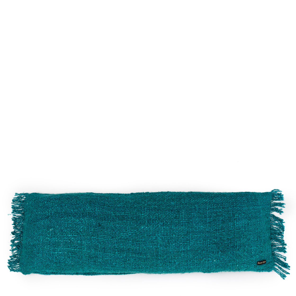 Langwerpig turquoise kussen met franjes en een klein zwart label, tegen een witte achtergrond.
