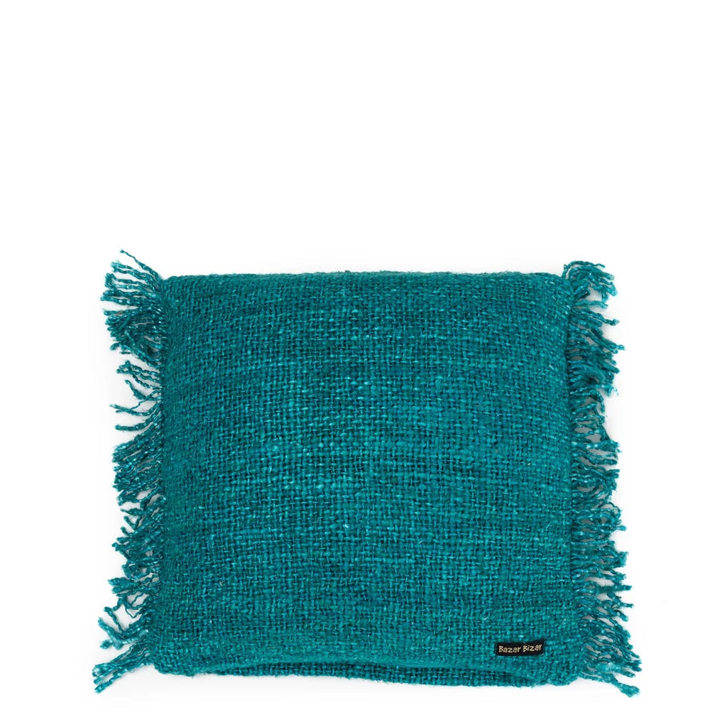 Turquoise geweven kussen met franjes en zwart label "Razer Blazer" rechtsbovenaan.