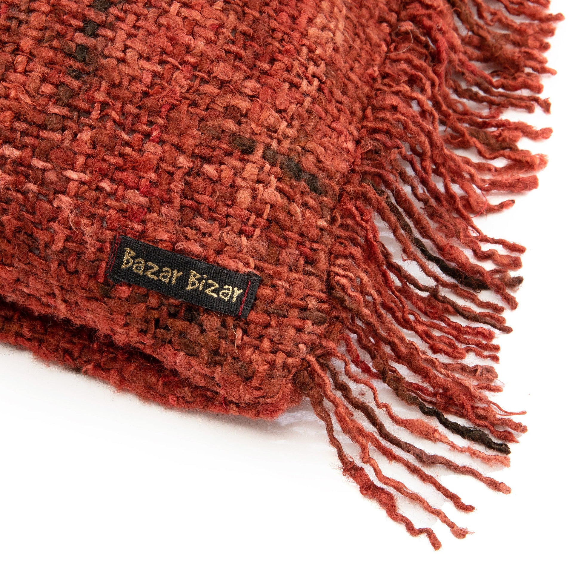 Handgeweven roodbruine sjaal met franjes, label "Bazar Bizar" zichtbaar, toont warme textuur en ambacht.