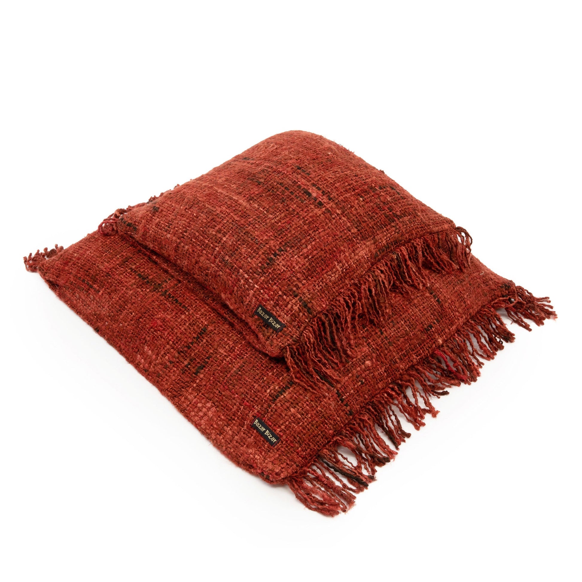 Twee rustieke terracotta kussens met franjes, stoffen label "Rust Fringe", stijlvolle textuurrijke uitstraling.