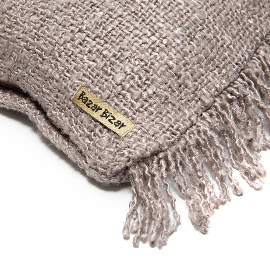 Grijze gebreide deken met franjes en label "Bazar Bizar". Comfortabele en stijlvolle structuur.