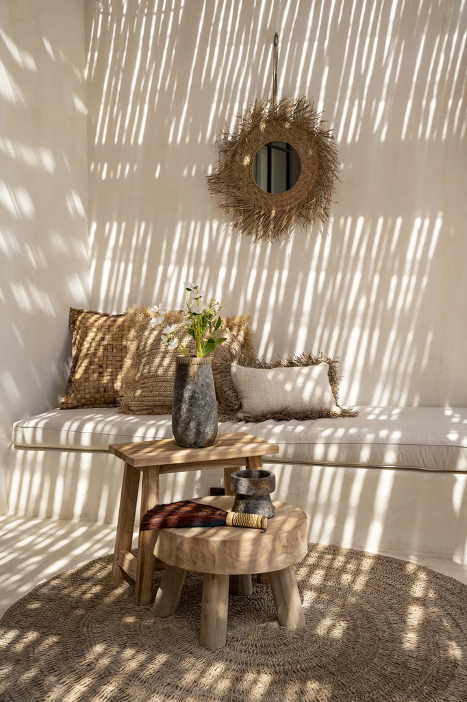 Gezellige ruimte met natuurlijke tinten, houten meubels, rieten decoraties en bloemen, met zonlicht door latten.