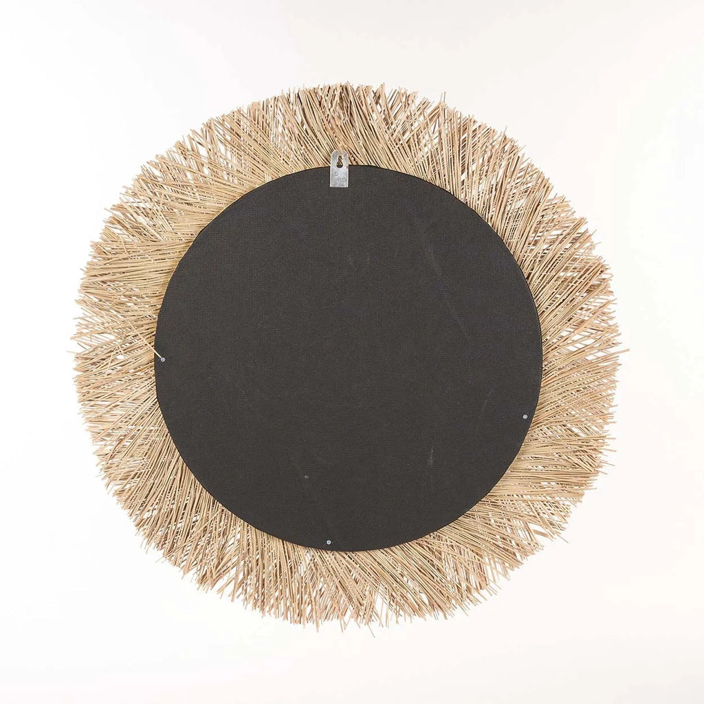Rond decoratiestuk met zwarte basis omringd door stroachtig beige franjes tegen een witte achtergrond.
