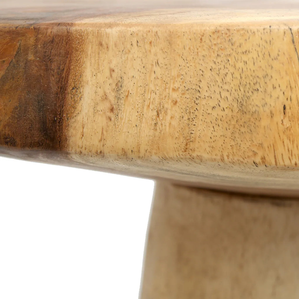 Detail van een gladde houten tafelrand met natuurlijke houtnerven en lichte textuur.