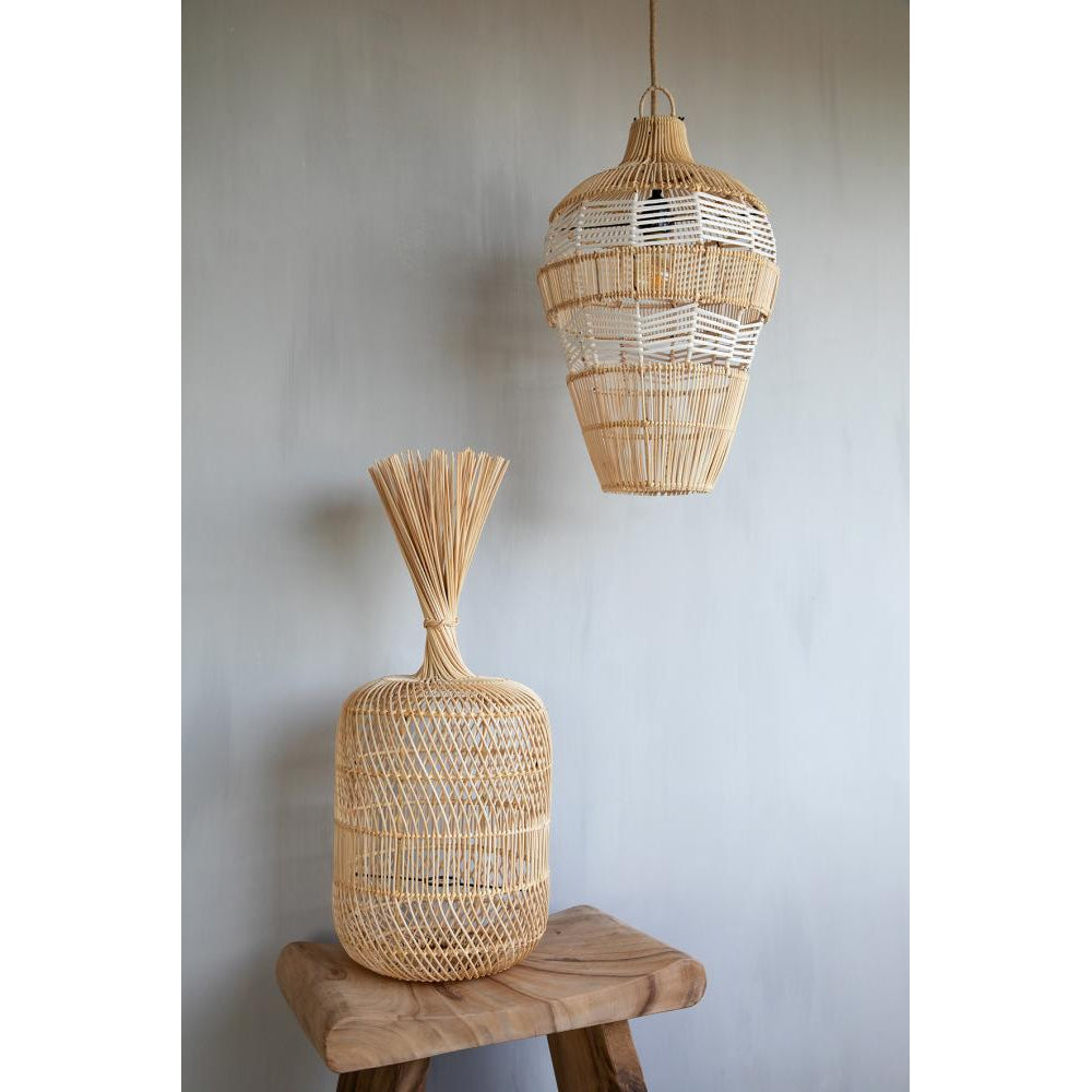 Hanglamp en vaas van gevlochten rotan op houten tafel, tegen neutrale muur. Rustieke, natuurlijke uitstraling.