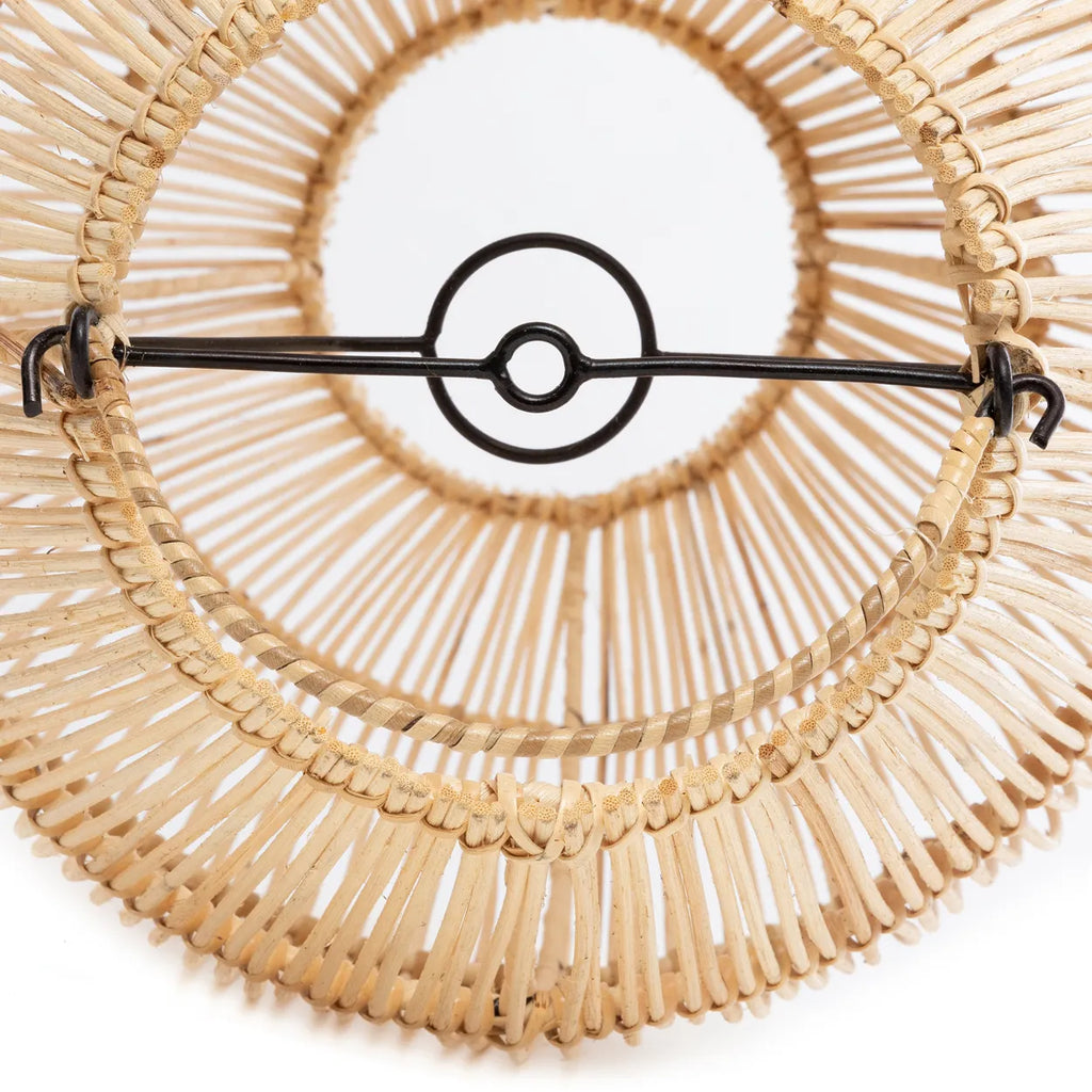 Detail van een geweven rotan lampenkap met metalen ophanging, kunstzinnig en symmetrisch ontworpen.