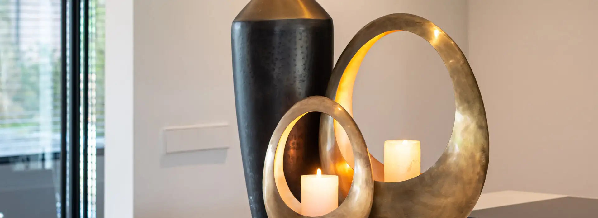 Bronskleurige, ronde kandelaars met een glad metallic afwerking.