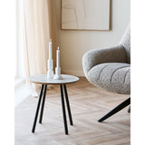 Gezellige styling met de House Nordic Aalst bijzettafel travertijnlook gestyled als kaarsenhouder naast loungefauteuil