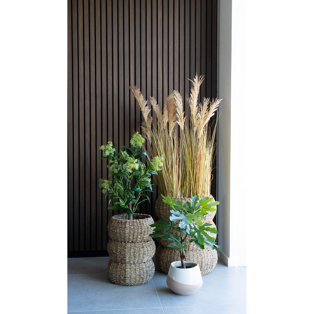 Beige keramische bloempot Ø20 cm met matte duotint, gecombineerd met rieten manden en gedroogd riet voor warme sfeer