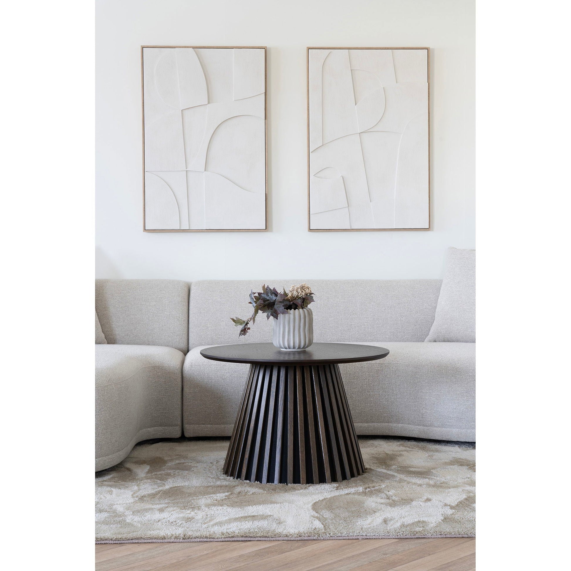 Moderne woonkamer met lichtgrijze keramische bloempot Ø15 cm op donker houten salontafel, geribbelde textuur accentueert minimalistische bank