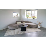 Cosy zithoek met House Nordic Boavista salontafel naast crèmekleurige fauteuil op beige vloerkleed en grijze tegelvloer