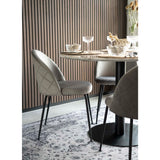 Stijlvolle eetkamer met fluwelen stoelen, een marmeren tafel en kristallen glazen op een elegant kleed.