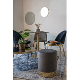 Stijlvolle eetkamer met een gouden tafel en donkerblauwe stoelen, omlijst door spiegels en planten op een vloerkleed.