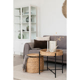 Naro bijzettafel van House Nordic gecombineerd met gevlochten opbergmand naast grijze bank, op beige vloerkleed