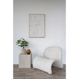 Huiskamer met House Nordic Prague bijzettafel in beige marmerlook naast een zachte fauteuil en stijlvolle wanddecoratie