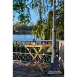 In de tuin staat Ronda dienbladtafel van House Nordic teakhout met lattenblad en keramische mok voor koffiemomenten